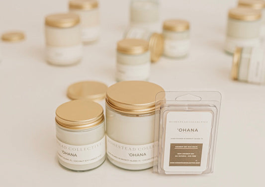 Candles with gold lids and 'Ohana' packaging on a light background