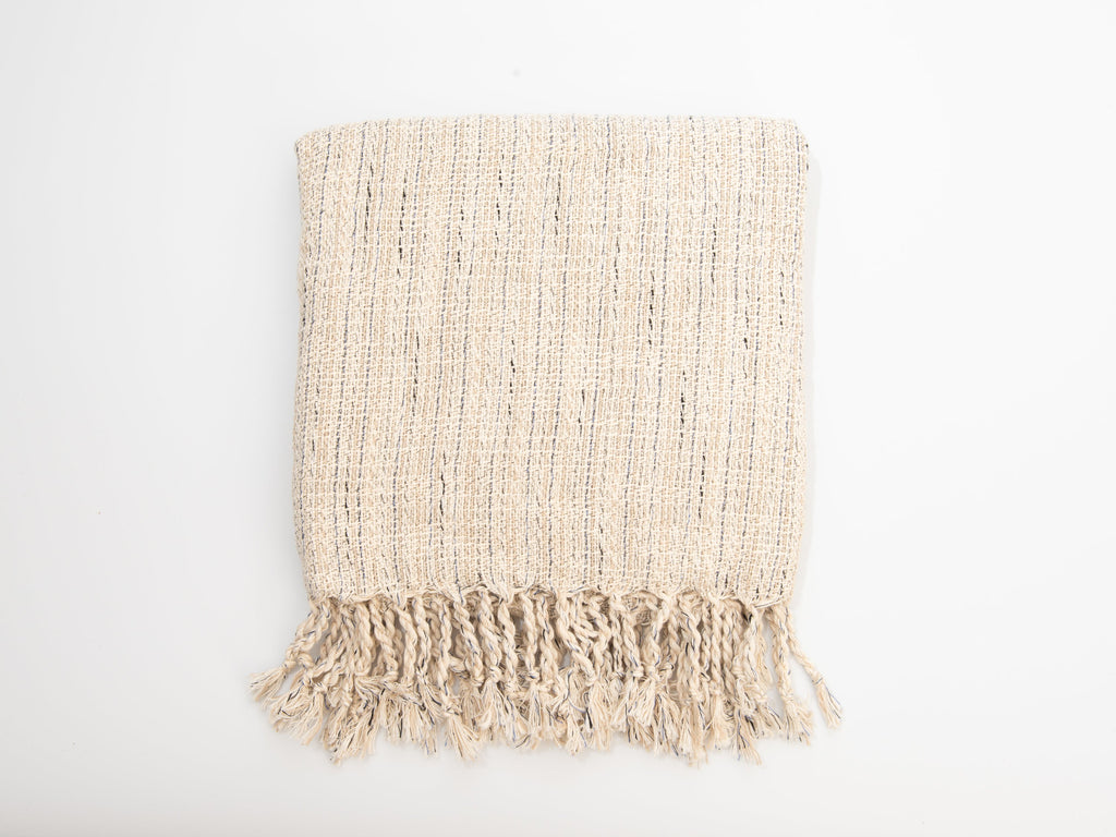 Beige woven blanket with fringes on a white background