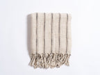 Textured towel with black stripes and frayed edges on a white background