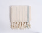 Beige towel with tassels on a white background