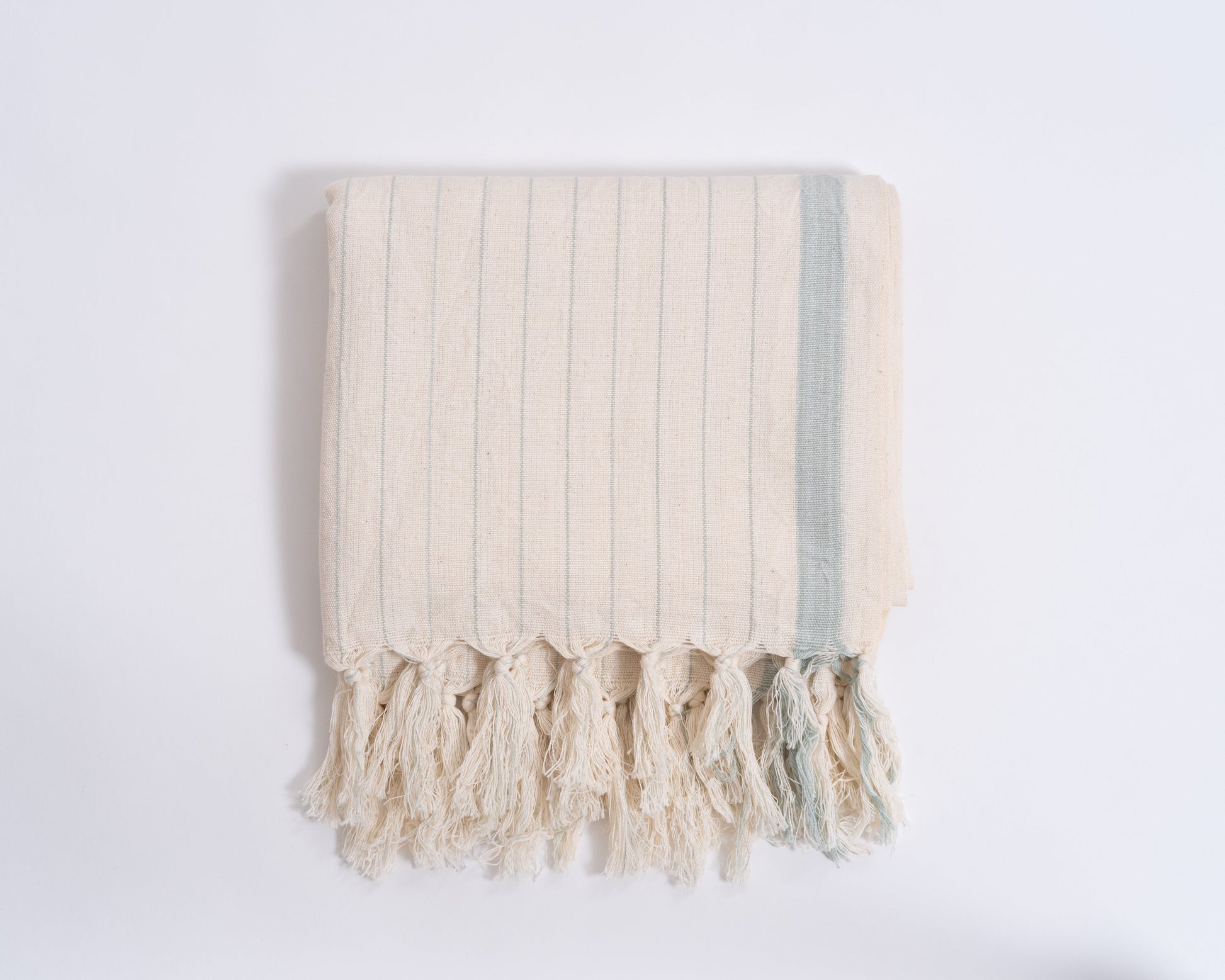 Beige towel with tassels on a white background