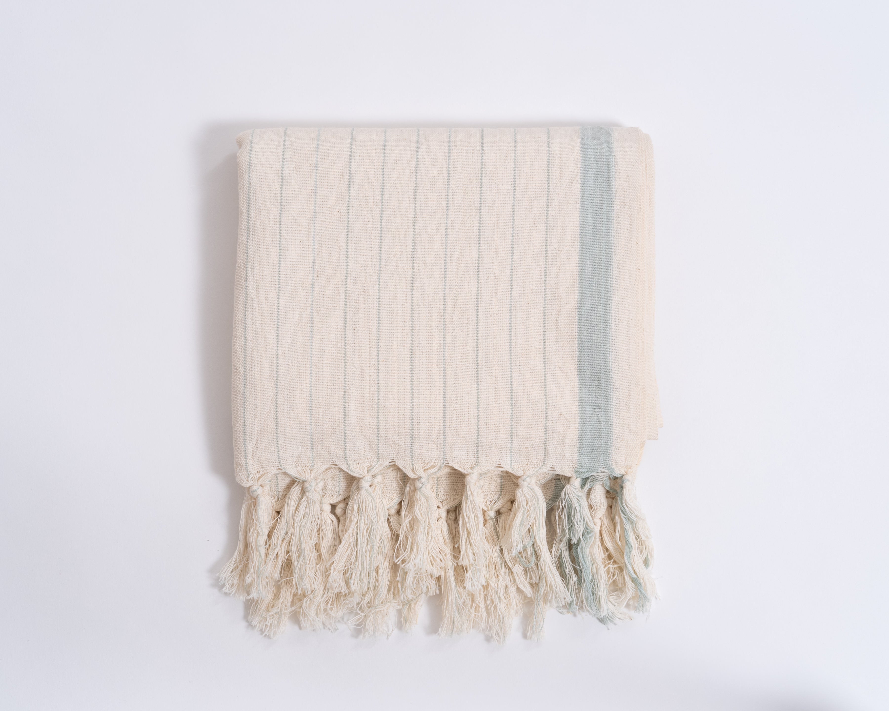 Beige towel with tassels on a white background