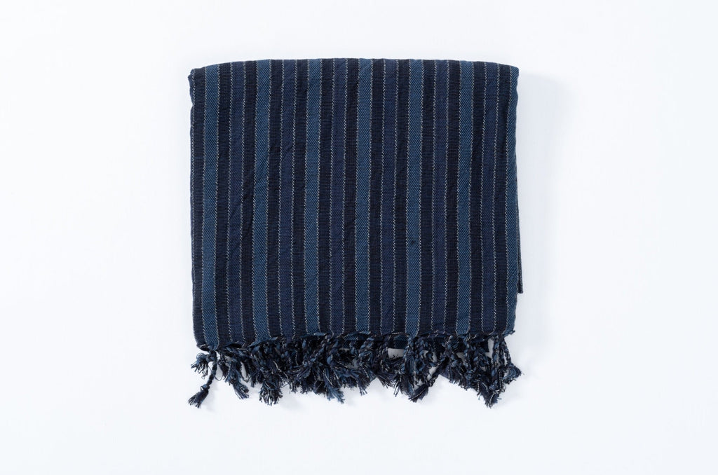Navy striped towel with fringes on a white background