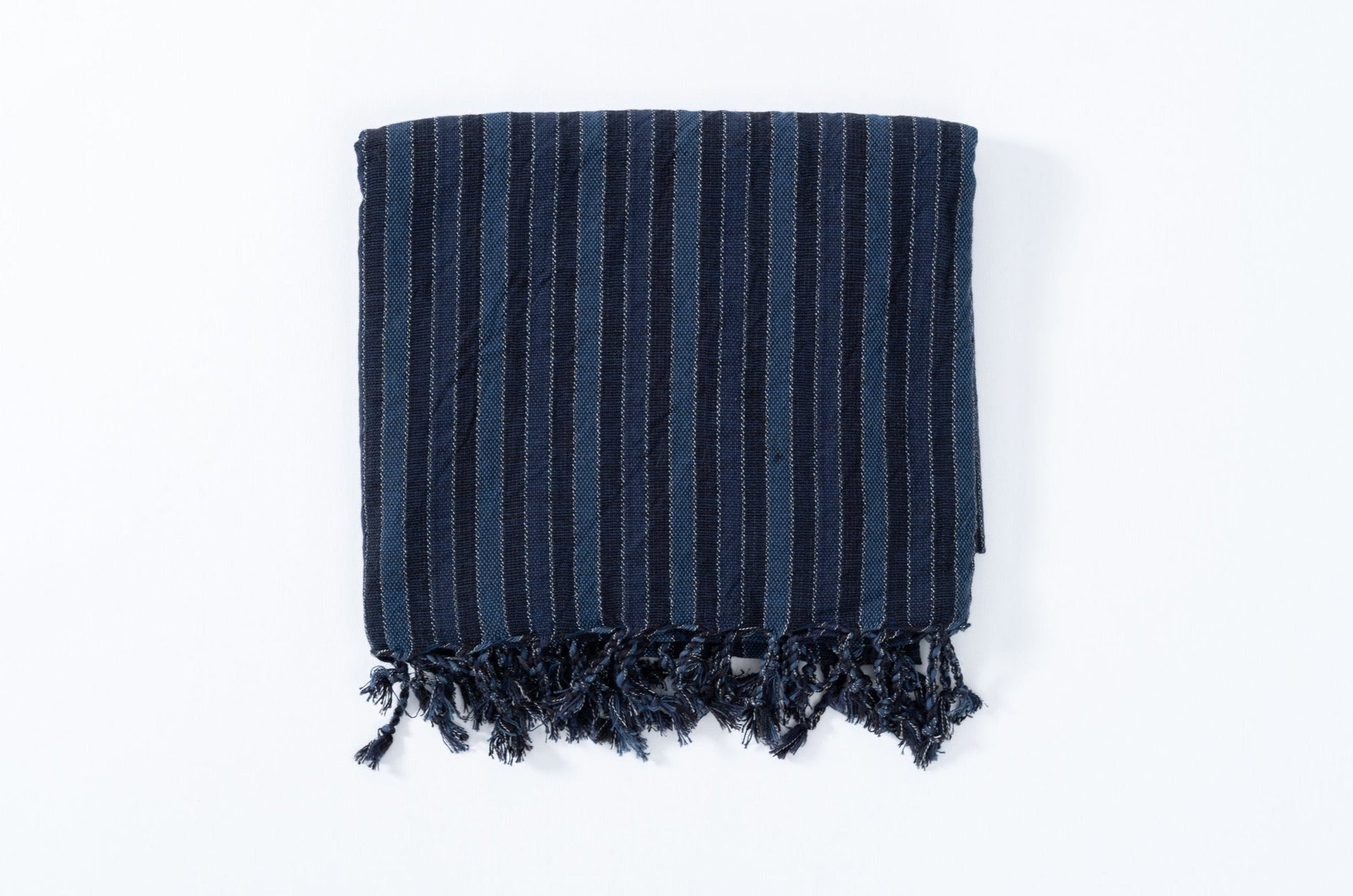 Navy striped towel with fringes on a white background