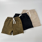Four pairs of shorts in different colors on a light gray background