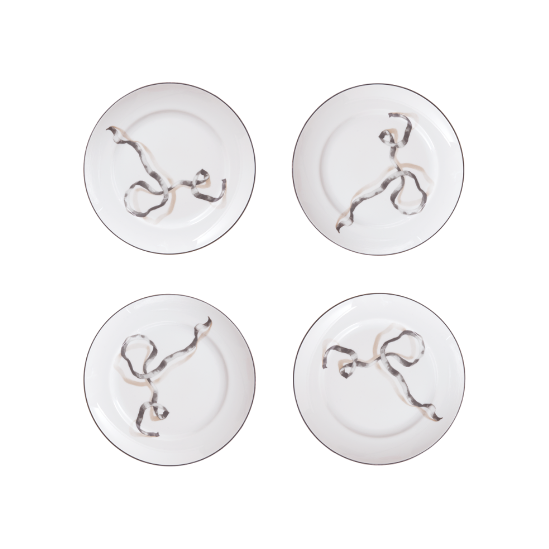 Four white plates with decorative elements on a white background