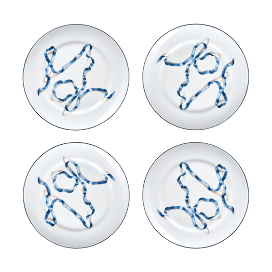 Four white plates with blue abstract designs on a white background
