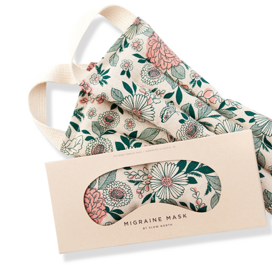 Floral-patterned migraine mask with packaging on a white background
