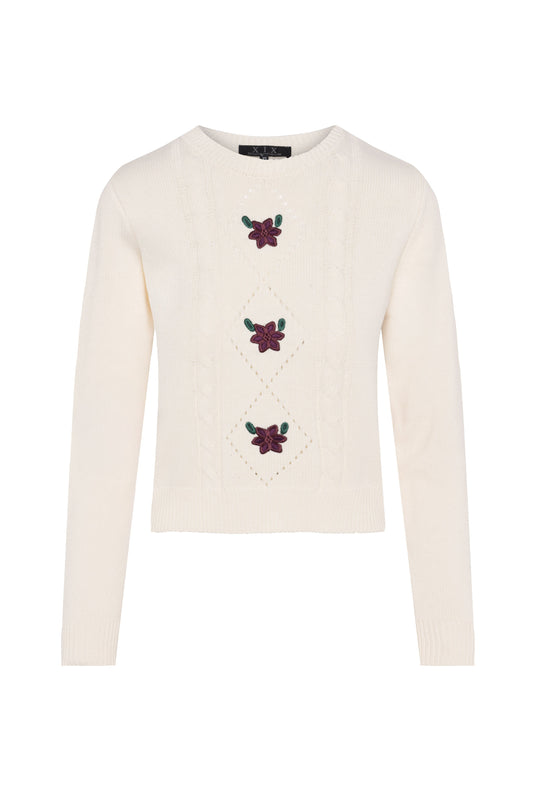 White sweater with floral embroidery on a white background