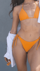Person wearing an orange bikini with a gray background