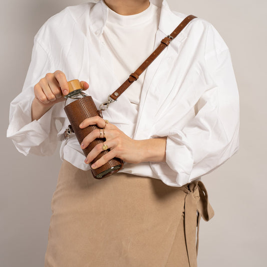 Leather water bottle holder with strap and glass bottle - The Peony Haus