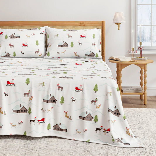 Bed with festive patterned bedding featuring Christmas elements in a room setting.