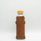 Leather water bottle holder with strap and glass bottle
