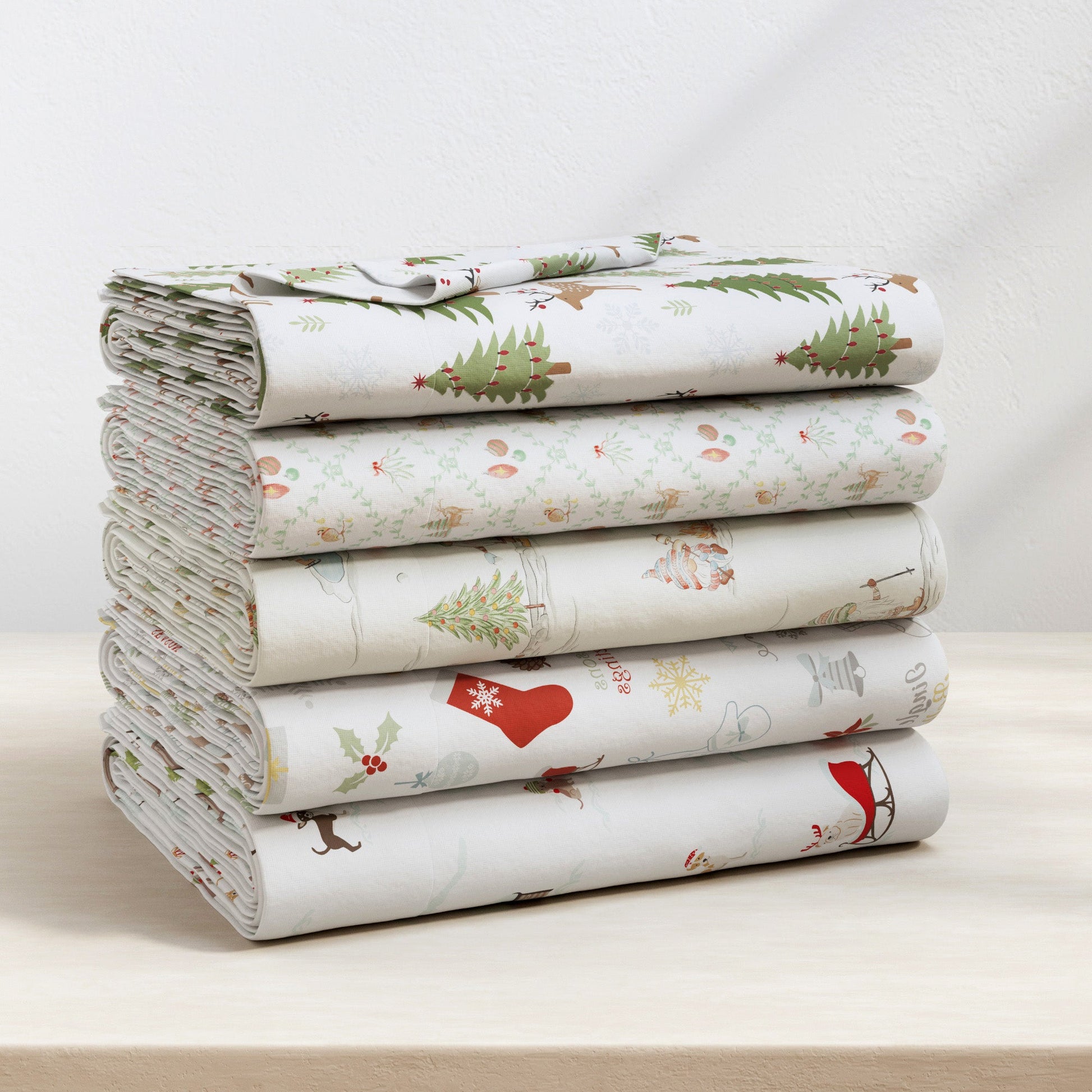 Stack of folded fabric with Christmas-themed patterns on a white surface